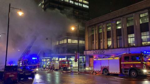 Smoke rises out of an office building above Forbidden Planet