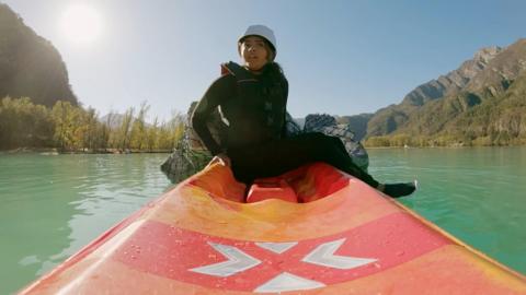 Woman in a wetsuit looks confused while sitting on a canoe