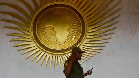 A security personnel stands by a sculpture representing the African continent, before the start of the 30th Ordinary Session of the Assembly of Heads of State and Government of the African Union (AU), in the entrance hall of the AU headquarters in Addis Ababa on January 27, 2018