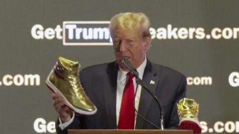 Donald trump holding golden sneaker while talking