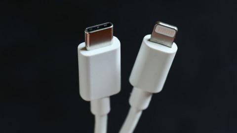 A USB Type-C charger beside Apple's proprietary Lightning cable
