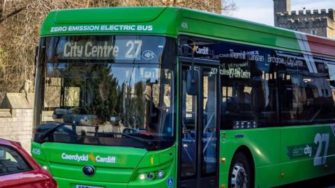 A green cardiff bus in the city centre