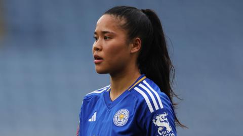 Asmita Ale wearing a blue Leicester City shirt. She has her black hair tied back. 