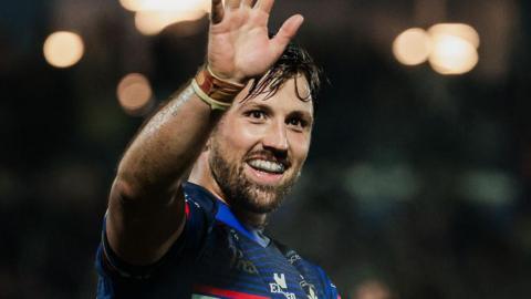 Tyson Smoothy holds his hand up in celebration at the end of a match.