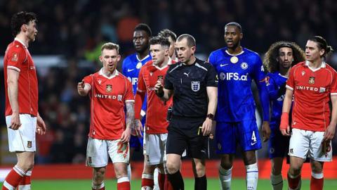 Lewis O'Brien of Wrexham speaks to Referee Peter Bankes as a VAR review takes place