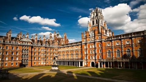 An historic red brick build university building set in lush green groundsin Egham, Surrey