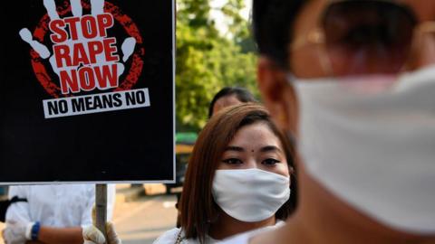 A volunteer from a non-governmental organisation (NGO) holds a placard during a protest in New Delhi on October 11, 2020 to condemn the alleged gang-rape and murder of a teenaged woman in Bool Garhi village at Hathras in Uttar Pradesh state