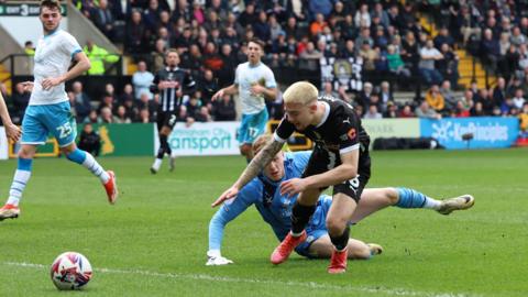 Notts County midfielder Charlie Whitaker dives over Crewe Alexandra goalkeeper Filip Marchall leg during the match between the two sides