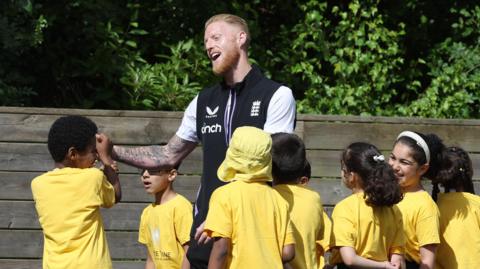 England captain Ben Stokes with some school children