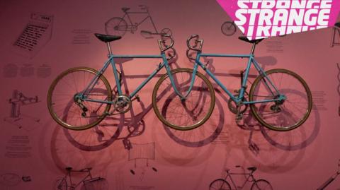 Two bikes hanging on a wall