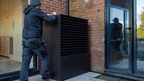 Air source heat pump being installed into a 1930's built house on the 29th of November 2024 near Ashford United Kingdom.