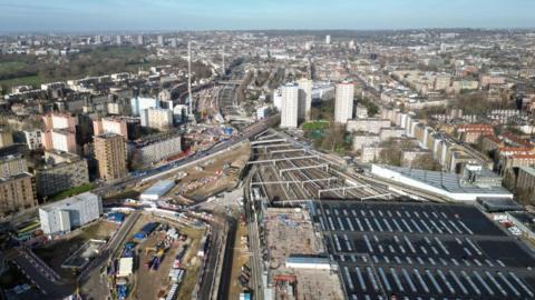 An aerial view of a construction site in west London. Beside the existing Euston station there is a cleared area with temporary building for the work