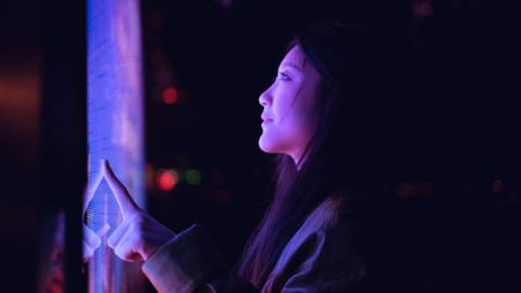 Woman looks at large digital display screen