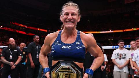 Kayla Harrison celebrates winning the UFC bantamweight title
