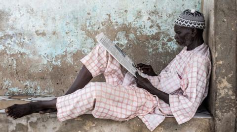 A man reads a newspaper in Senegal