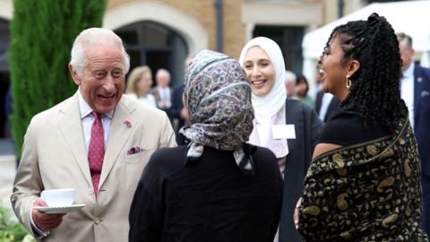 King Charles meets staff during a visit to the Oxford Centre for Islamic Studies in Oxford.