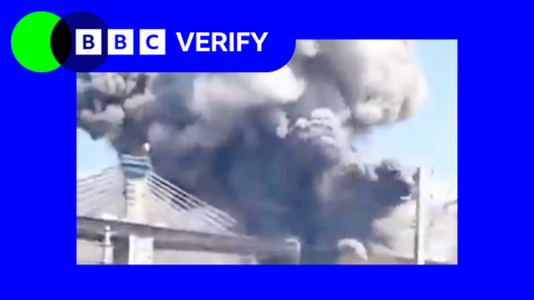 Smoke rises from a strike on the B1 Bridge in Iran. The photo is imposed over the BBC Verify colours and branding. 