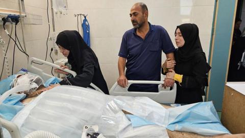 Alaa al-Najjar (2nd L) visits her husband (L) in Nasser hospital
