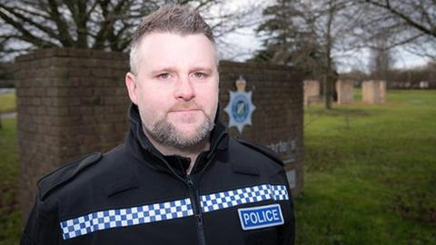 Image of police officer outside police headquarters