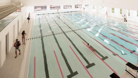 A computer generated image of what the pool at the proposed new Stevenage leisure centre could look like. There are ten swimming lanes with a number of people walking beside the pool. There are seats for people to sit to the right of the pool. 