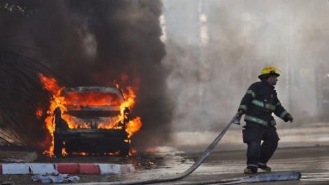 Israel firefighter beside burning car in Sderot (12/11/19)