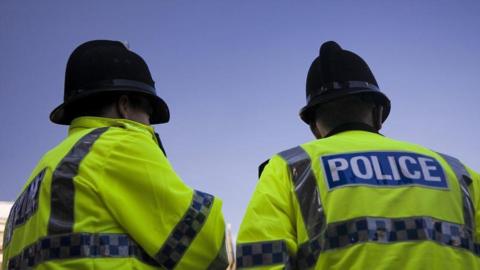 Two police officers facing away from the camera