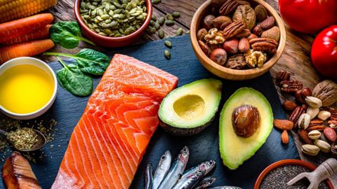 A variety of seafood, vegetables, fruits, nuts and seeds on a table