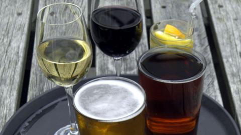Various drink on a black tray on a picnic table