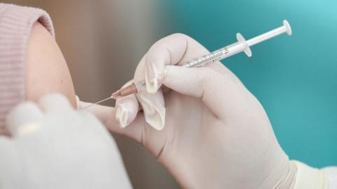 A vaccine going into someone's arm