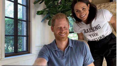 Harry and Meghan, who is wearing a T-shirt emblazoned with the 'raising the future' logo
