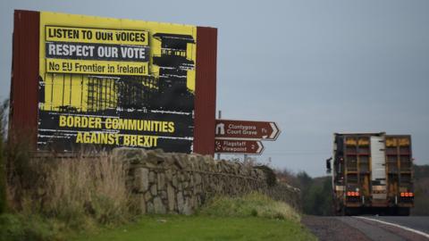 A lorry passing an anti-Brexit sign on the Irish border