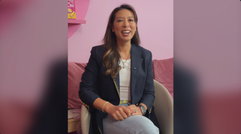 The co-founder of Little Moons, Vivien Wong smiles. She wears a blue blazer and jeans and has long, straight brown hair.