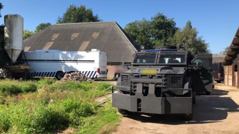 Stables with an armoured vehicle in front