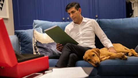 Chancellor Rishi Sunak, kept company by his red Labrador retriever puppy Nova, works on his budget speech in his flat in Downing Street October 2021
