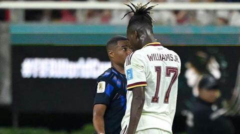 Nico Williams squares up to a Uruguay player