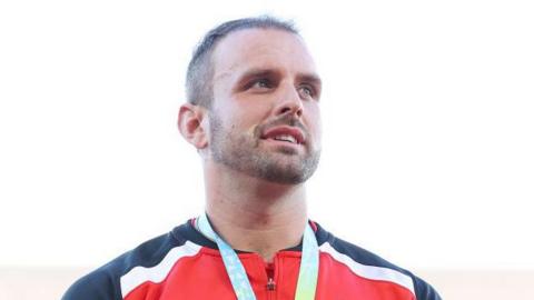 Aled Sion Davies stood on the podium after winning discus gold at the 2022 Commonwealth Games in Birmingham