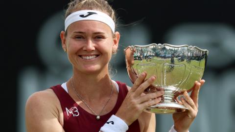 Marie Bouzkova smiles as she holds the Nottingham Open trophy