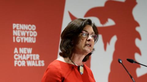 Eluned Morgan, dressed in red, addresses the manifesto launch event in Swansea