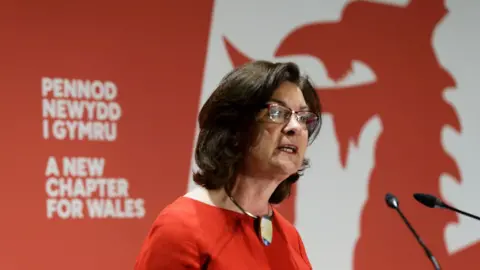 Eluned Morgan, dressed in red, addresses the manifesto launch event in Swansea