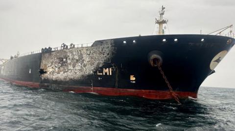 An oil tanker showing damage and scotch marks to its side
