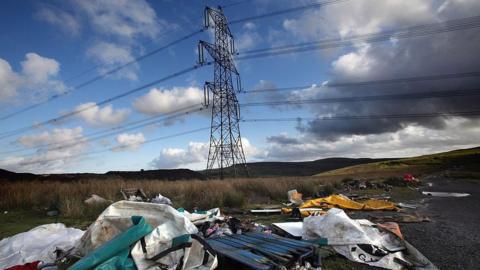 Sbwriel wedi'i adael dan beilonau trydan ger Merthyr Tydfil