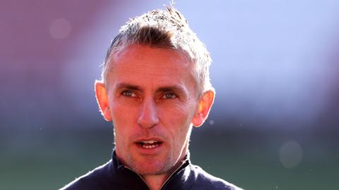 Kieran McKenna head and shoulders picture, as he wears a zip-up top