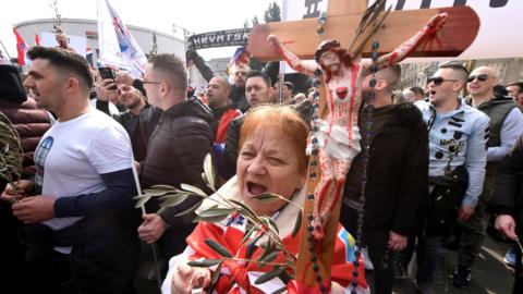 A woman holding a Catholic cross joins a traditionalist march against an EU treaty in Zagreb, Croatia on Saturday