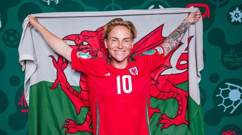 Chwaraewraig canol cae Cymru Jess Fishlock a baner Cymru