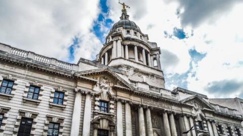 The Old Bailey Court in London seen from the outside. The sky is broken up with white clouds