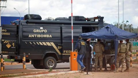 Security forces work as a robot of the federal police bomb squad is seen near what is believed to be an explosive artifact in Brasilia, Brazil, December 24, 2022.