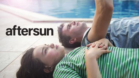 Dad and daughter lie on the ground by a pool looking up to the sky