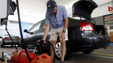 A man fills gallons of gasoline in the city of Ponce, on the south coast of Puerto Rico