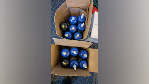 Two cardboard boxes containing blue canisters with metal tops.