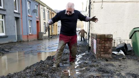  Resident Rob Scholes, 75, moves through mud at the site of a mudslide, in the aftermath of Storm Bert, in Cwmtillery, South Wales